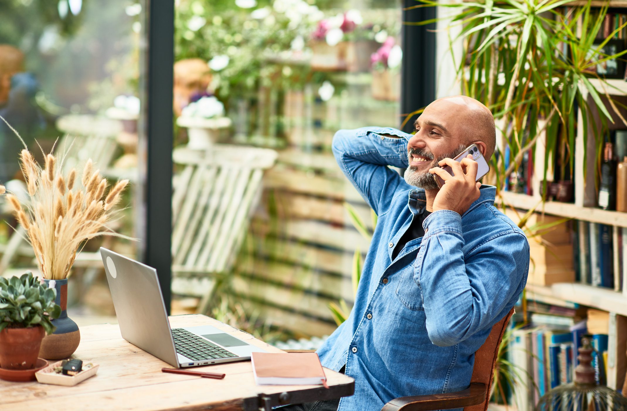 Cheerful businessman talking on mobile phone at home